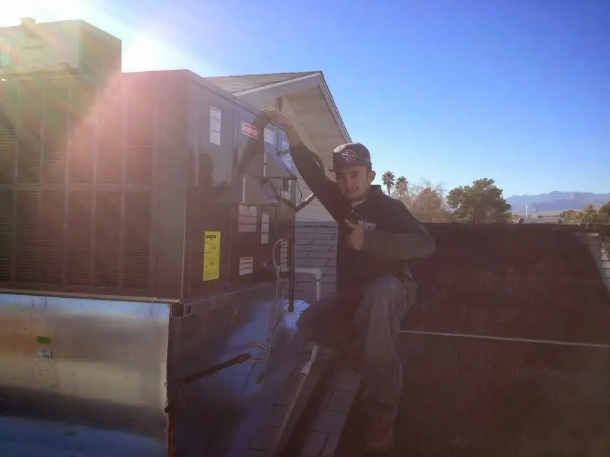 HVAC technician performing Air Duct Cleaning on a rooftop unit in Jacksonville